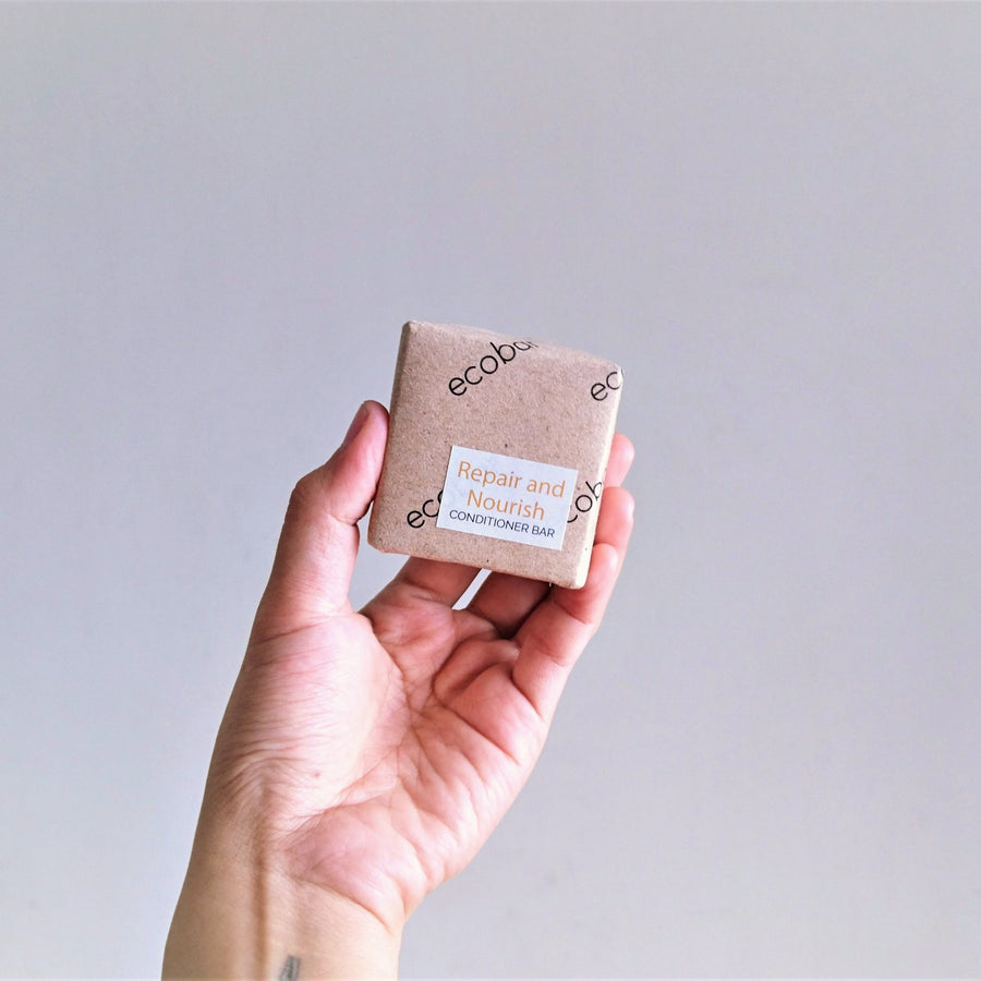 hand-holding-ecobar-repair-and-nourish-conditioner-bar-wrapped-in-kraft-paper